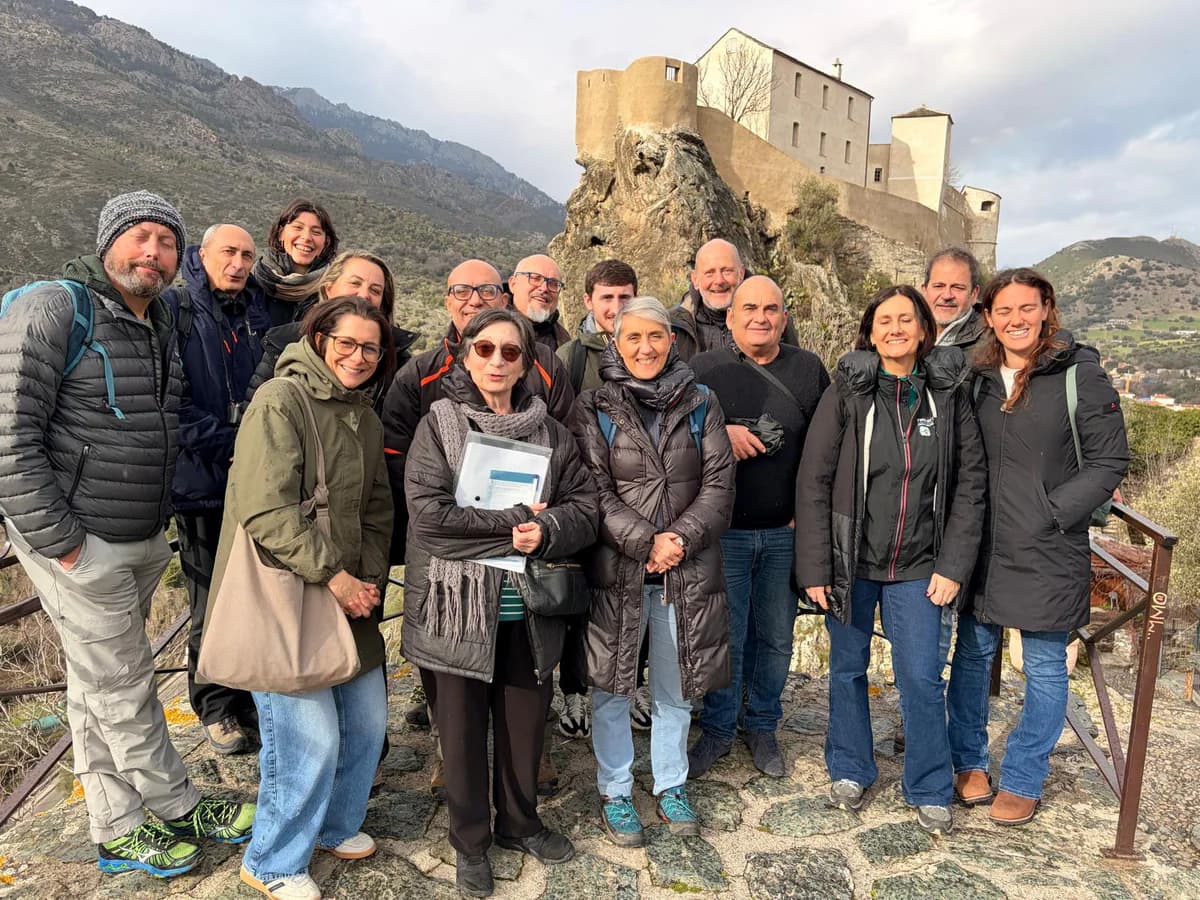 Les partenaires du projet UNIT-GEOPARKS devant une citadelle et un paysage montagneux